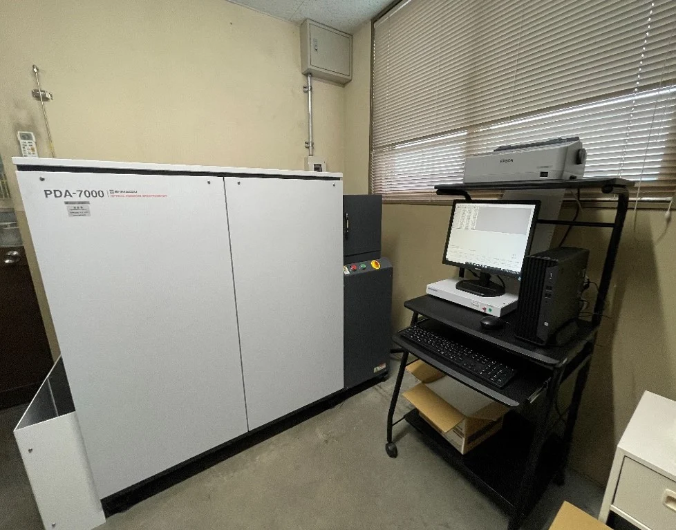 株式会社上田合金所の発光分光分析機（島津製作所 PDA-7000）と、分析結果を表示するパソコン